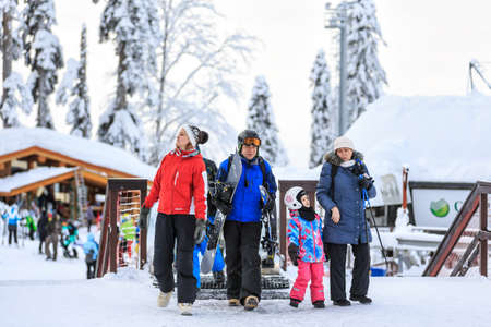 Sochi, Russia - January 9, 2015: Sochi winter ski resorts host skiers and snowboarders during 6 months a year. People carrying ski and snowboard equipment walked out for a ski ride on a snowy dayのeditorial素材
