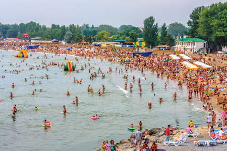 Anapa, Russia - July 26, 2008: Crowds of people relaxing on sandy beach and bathing in sea water in Anapa seaside resort at seashore of Black Sea coast on sunny summer dayのeditorial素材