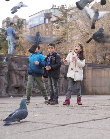 Ankara/Turkey-March 3 2018: Children feeding pigeons and enjoying the day in Kizilay, City center of Ankaraのeditorial素材