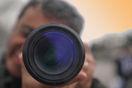 Blurred image of a smiling man looks into the camera's viewfinder and takes pictureの写真素材