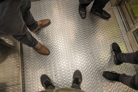 Four men in elevator. Concept of men's club.の写真素材