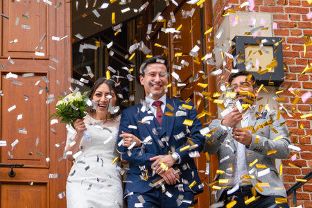 Brussels, Belgium - October 4 2019: Bride and groom just in front of a red brick building under the colorful confettiのeditorial素材