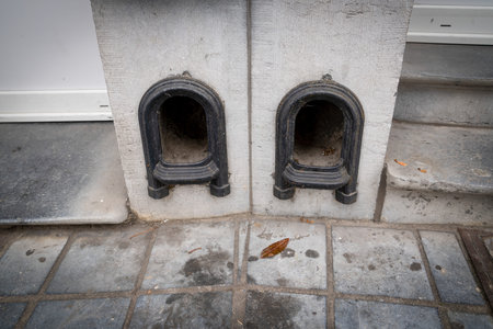 Boot scraper in a low wall at the entrance to the drive of a terraced house. Metal arch shaped with...