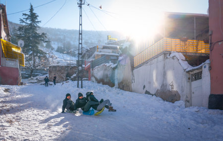 Afyonkarahisar/Turkey - January 11 2020: Children enjoys snow on the street among old housesのeditorial素材