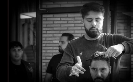 Brussels, Belgium - October 4 2019: Man getting haircut in a busy hair salon. Black and white image.のeditorial素材
