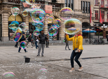 Ghent/Belgium - October 10, 2019: Man doing People Big soap bubbles in central plaza of Ghent, the capital of the East Flanders province in Belgium.のeditorial素材