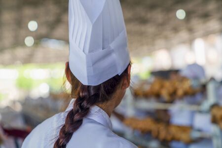Many roasted chickens in a row in culinary and tourism Festival in Mengen, Bolu, Turkey. Rear (back) view of chef woman in festival.の写真素材