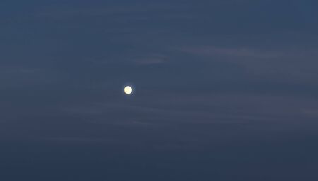 Moon in the evening sky during blue hour.の写真素材