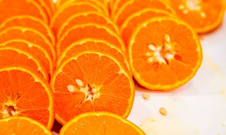 Fresh cut orange fruit background, many pieces of oranges, macro close up photo of healthy food, top viewの写真素材