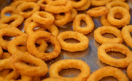 Many crunchy fried onion rings are ready to service in a hotel restaurantの写真素材