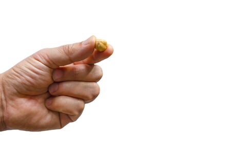 Human finger holding one hazelnut with isolated white backgroundの写真素材