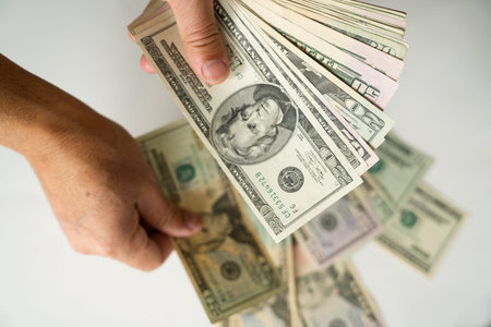 Selective focus of hands counting dollar bills isolated on white background. Counting or spending...