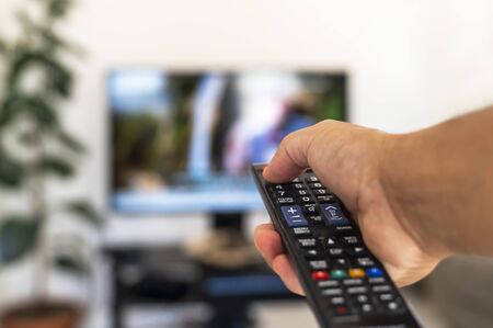 Watching tv and using remote controlの写真素材