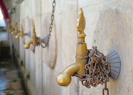 Metal yellow faucet fountains in a row in old traditional cityの写真素材