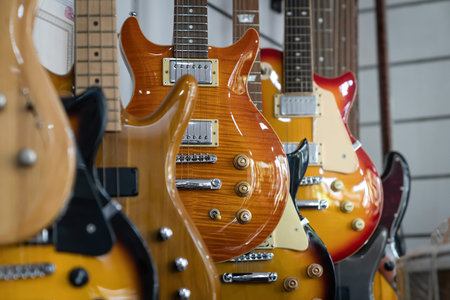 Selective focus of different electric guitars in a row hanging in a modern musical shop
