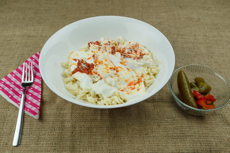 Turkish stile spiral pasta is served with yogurt and tomato sauce