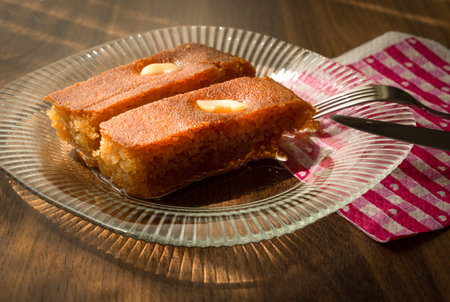 Turkish Dessert sambali, sambaba or sam tatlisi served in a plate with fork and knife on brown...