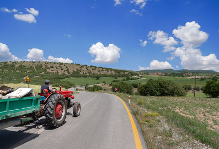 A farmer goes by a tractor on the village road that goes curling. Village life in Turkey....