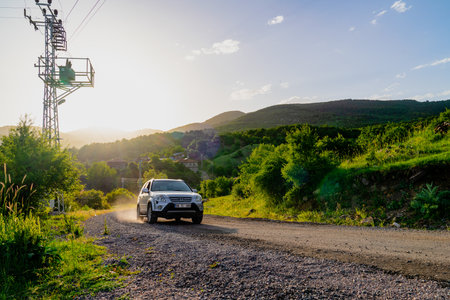 Kizilcahamam, Ankara/Turkey - June 07 2020: View a village in sunset with electric transformer near the road. Car on the road and coming from the village. Kizilcahamam, Ankara, Turkeyのeditorial素材