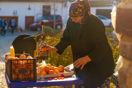 Ankara/Turkey-February 17 2019: Orange juice extractor on the street and local woman sells juice in touristic neighborhood near Ankara Castleのeditorial素材