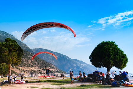 Fethiye, Mugla/Turkey - August 19 2018:  Tandem paragliders are landing on Belcekiz Beach in Oludeniz.のeditorial素材