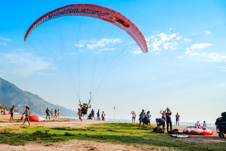Fethiye, Mugla/Turkey - August 19 2018:  Tandem paragliders are landing on Belcekiz Beach in Oludeniz.のeditorial素材