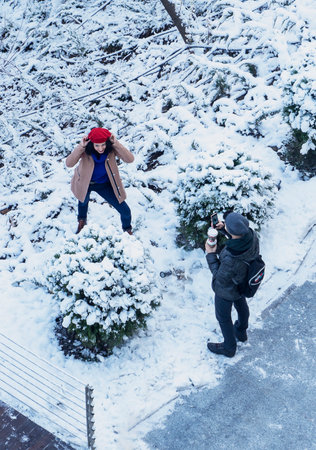 Ankara/Turkey-December 13 2018: Aerial view of a park. Young couple taking photo via cellphone under snow in a winter timeのeditorial素材