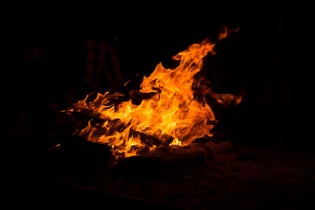 Camping fire in total darkness during night and nobody around