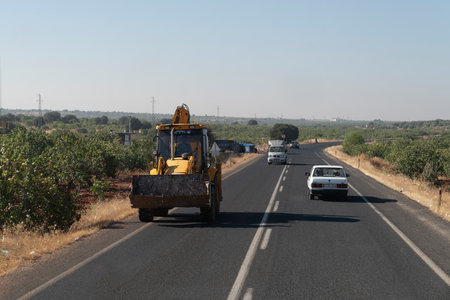 Halfeti, Sanliurfa / Turkey- September 15 2020: The excavator drives on the highwayのeditorial素材