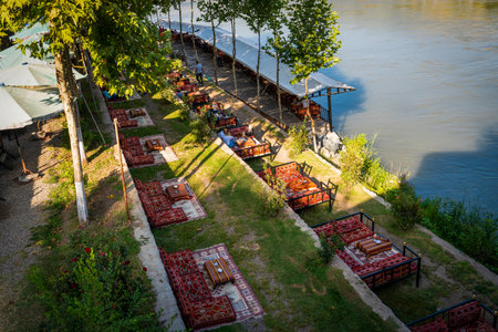 Diyarbakir, Turkey- September 17 2020: People enjoy oriental styled cafe restaurant next to Ten Eyed Bridge (On Gozlu Kopru in Turkish), historical bridge on Tigris River.のeditorial素材