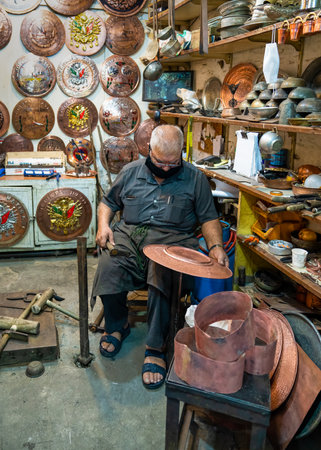 Sanli Urfa, Turkey: September 12 2020: A Coppersmith Busily Making a Copper Plate in Copper Bazaarのeditorial素材