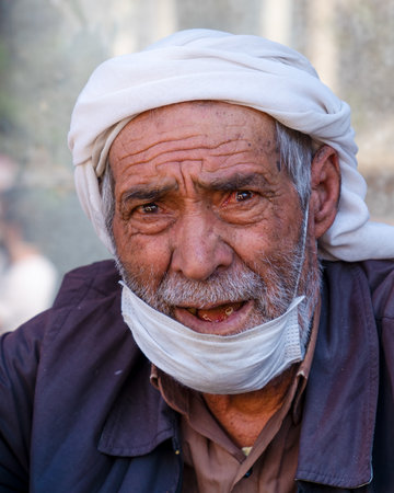 Sanli Urfa, Turkey: September 12 2020: Old man with a white turban on his head and mask in his chin looking.のeditorial素材