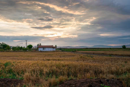 A white country house in the evening and under a red and blue sky.の写真素材