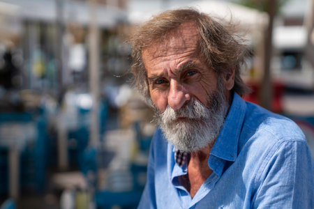 Kusadasi, Aydin, Turkey - August 22, 2021: A bearded tourist in a blue shirt look at the camera.のeditorial素材