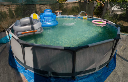 Blue plastic pool in the garden.