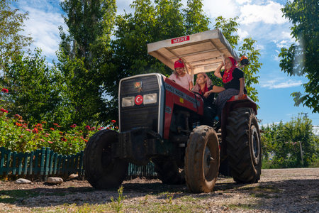Ankara, Turkey-  September 18 2021: Woman driving tractor and other women sitting in the cabin.のeditorial素材