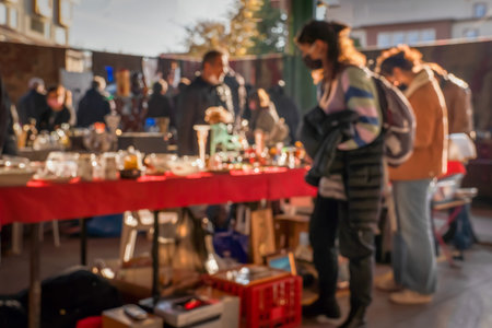 Blurred unfocused view of a flea market with customers and sellers.