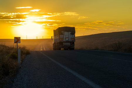 Back view of truck drives on a country road and the sunset in background.の写真素材