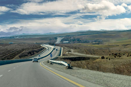 Curving asphalt road between Baku and Shamakhi districts and hills in background, Azerbaijanの写真素材
