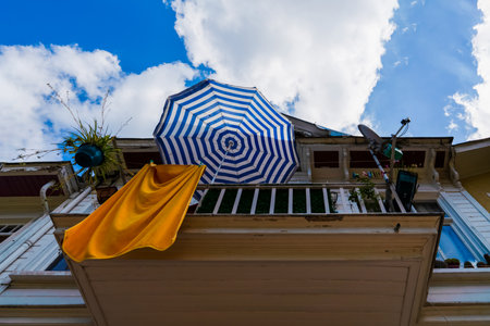 Umbrella and dried towel on the balcony of a wooden house in summer. Summer vacation concept.の写真素材