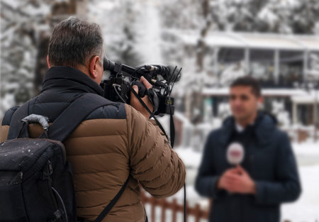 Back view of news cameraman with blur reporter together