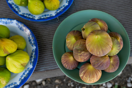Top view of green and red figs in a plate are ready to eat in the country.の写真素材