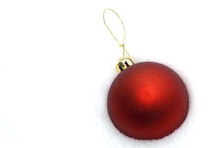 Red Christmas ball lying in snow crustの写真素材