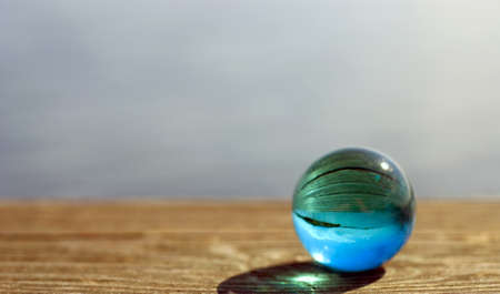 Beautiful summer coast seen through a blue glass ballの写真素材