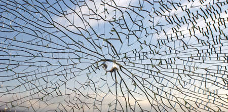 Broken glass,background of cracked window against blue skyの写真素材