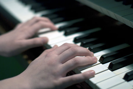 Close up of young girls hands, playing the keys