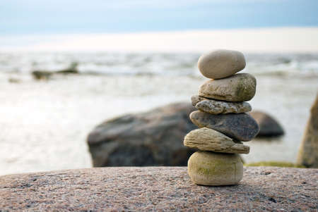 Stack of stones on sea shore in evening light, close upの写真素材