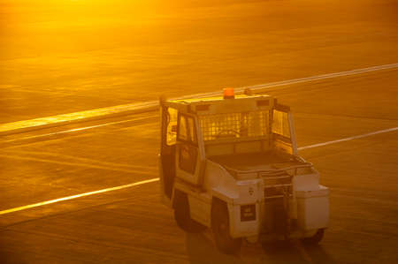Airport towing truck in early morning sunlightの写真素材