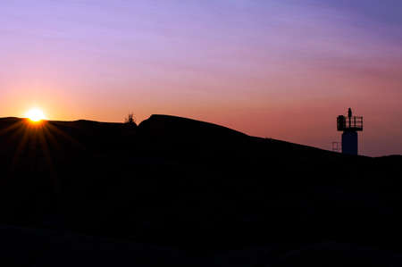 Silhouette of lighthouse in summer sunsetの写真素材