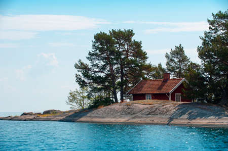Red little summer cottage on islandの写真素材